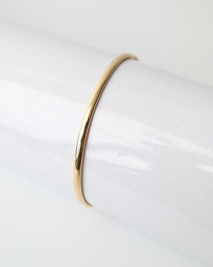 9kt solid gold Classic Oval Bangle with a polished finish, lightweight hollow construction and flexible design, photographed on a white background.