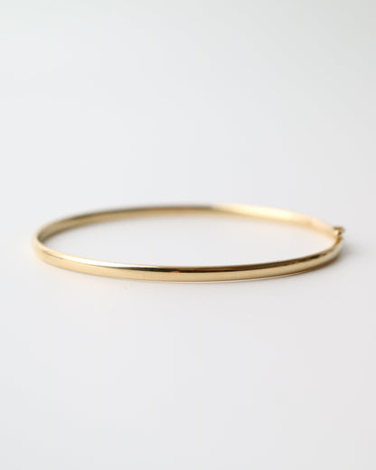 9kt solid gold Classic Oval Bangle with a polished finish, lightweight hollow construction and flexible design, photographed on a white background.