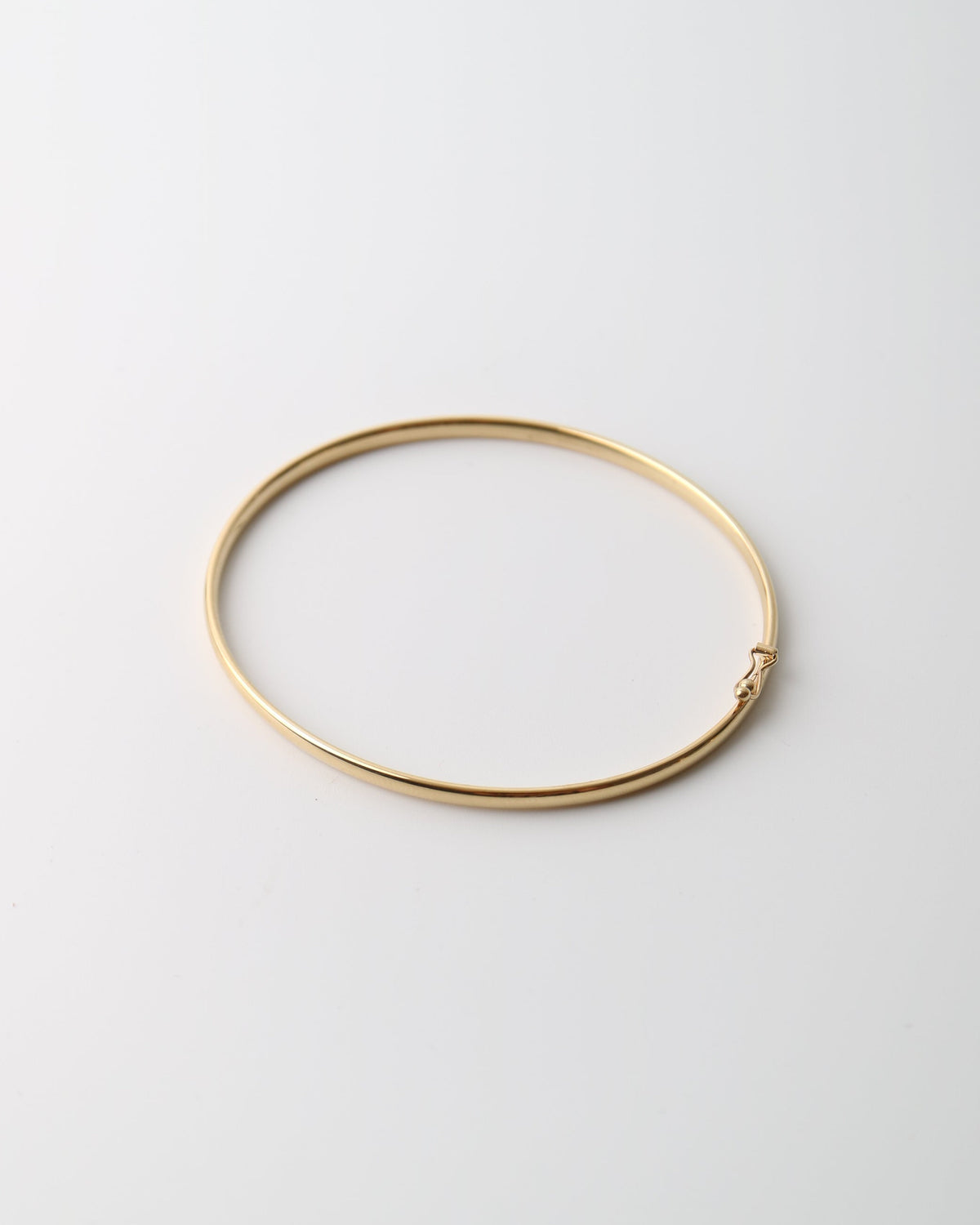 9kt solid gold Classic Oval Bangle with a polished finish, lightweight hollow construction and flexible design, photographed on a white background.