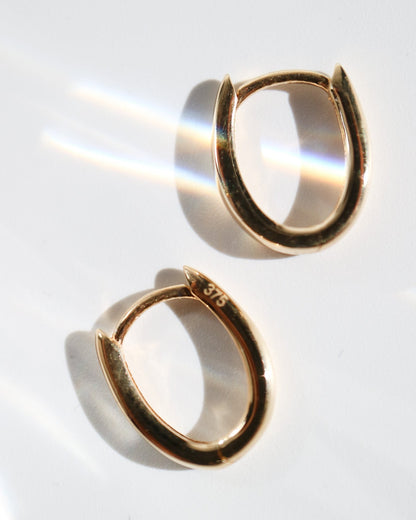 9kt solid gold Rounded V-Shaped Huggie Earrings featuring a polished finish, rounded silhouette and subtle V-shaped base, photographed on white from above