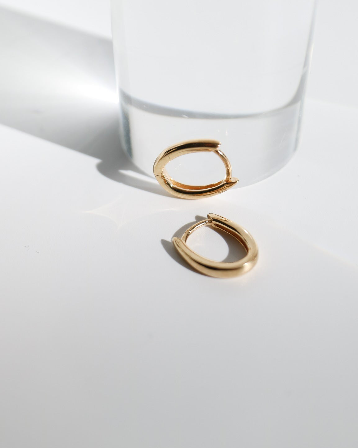 9kt solid gold Rounded V-Shaped Huggie Earrings featuring a polished finish, rounded silhouette and subtle V-shaped base, photographed on white