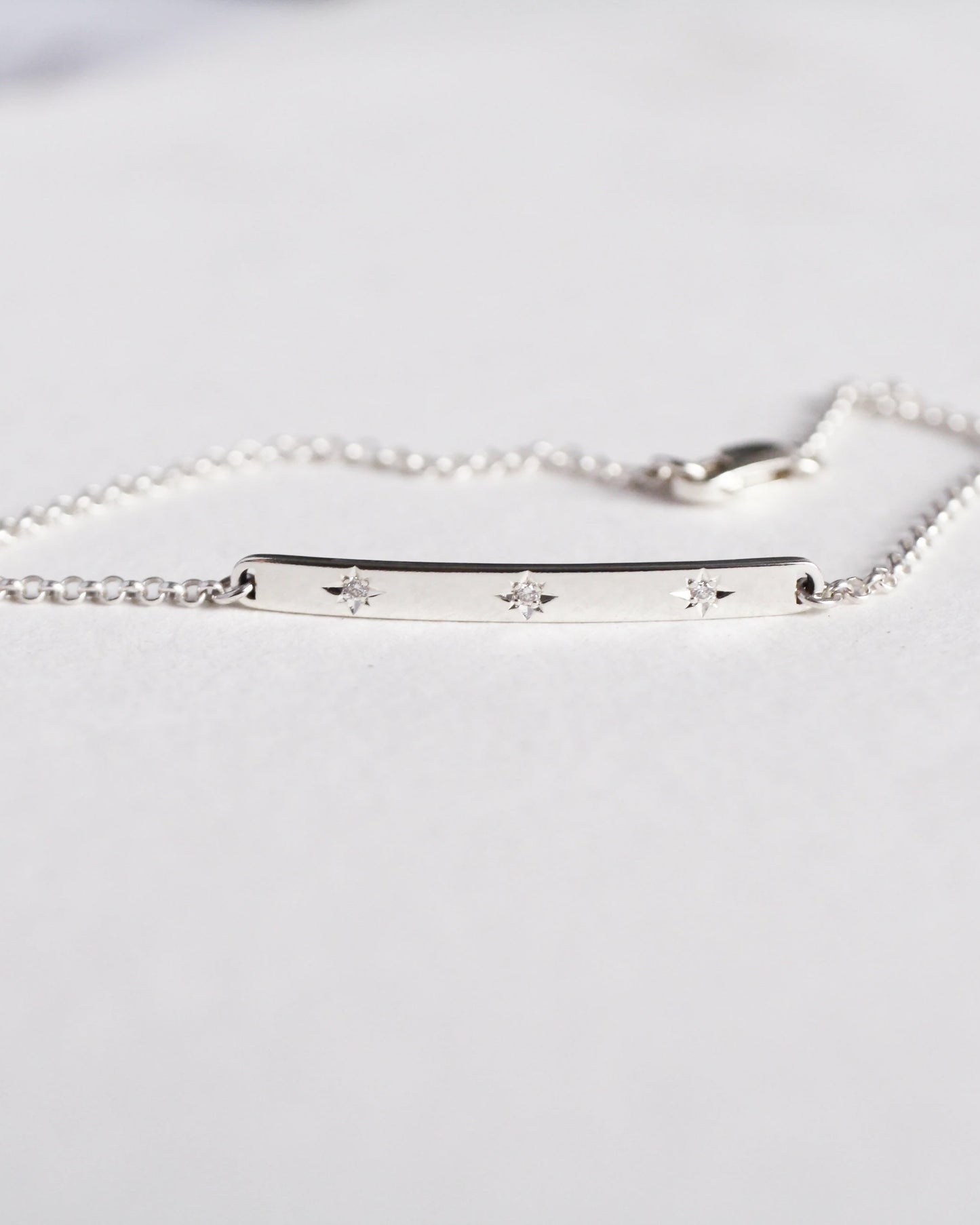 Silver bracelet with engraved stars on a white background