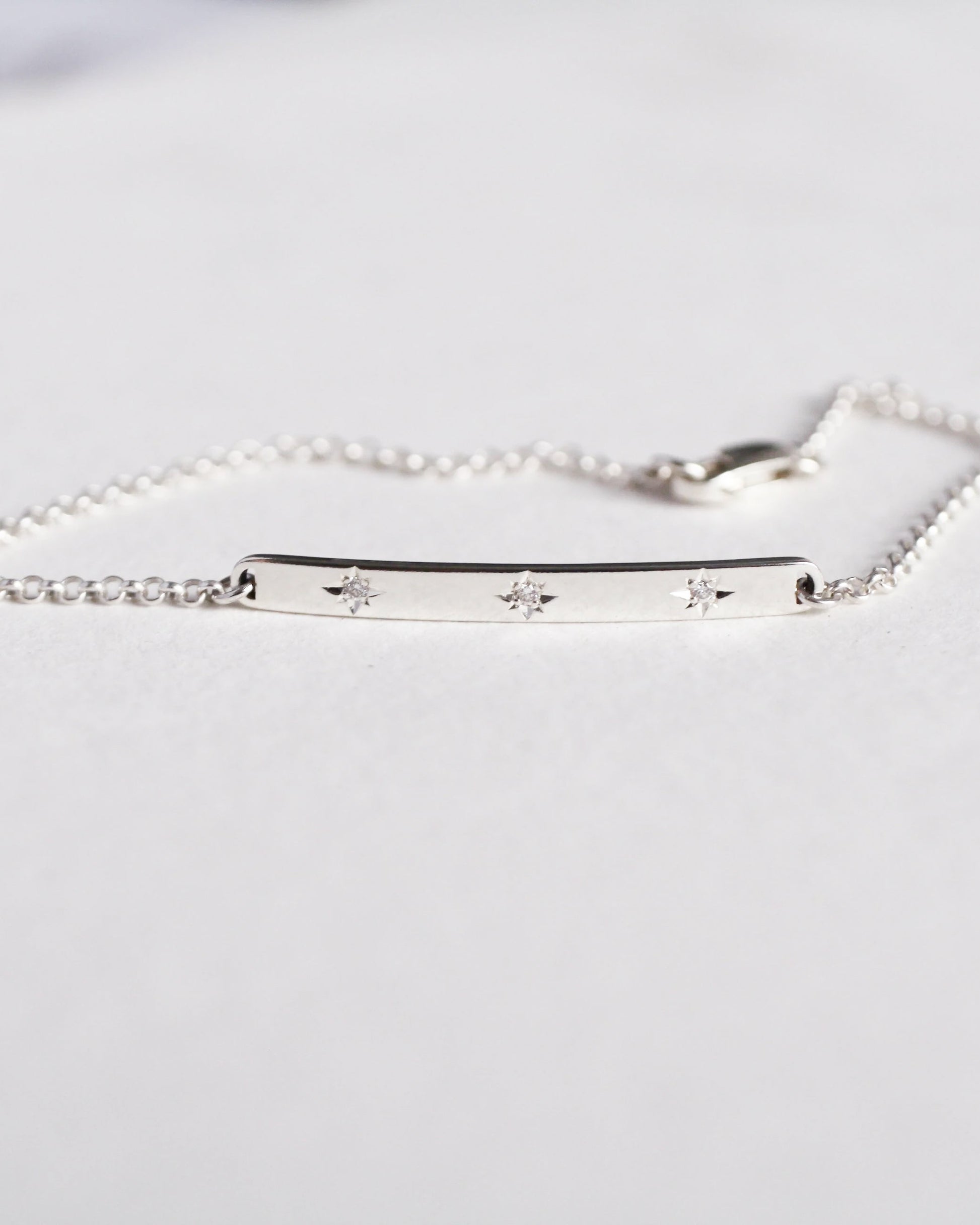 Silver bracelet with engraved stars on a white background