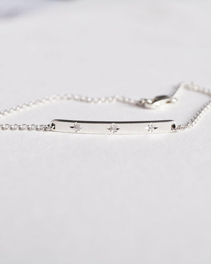 Silver bracelet with engraved stars on a white background