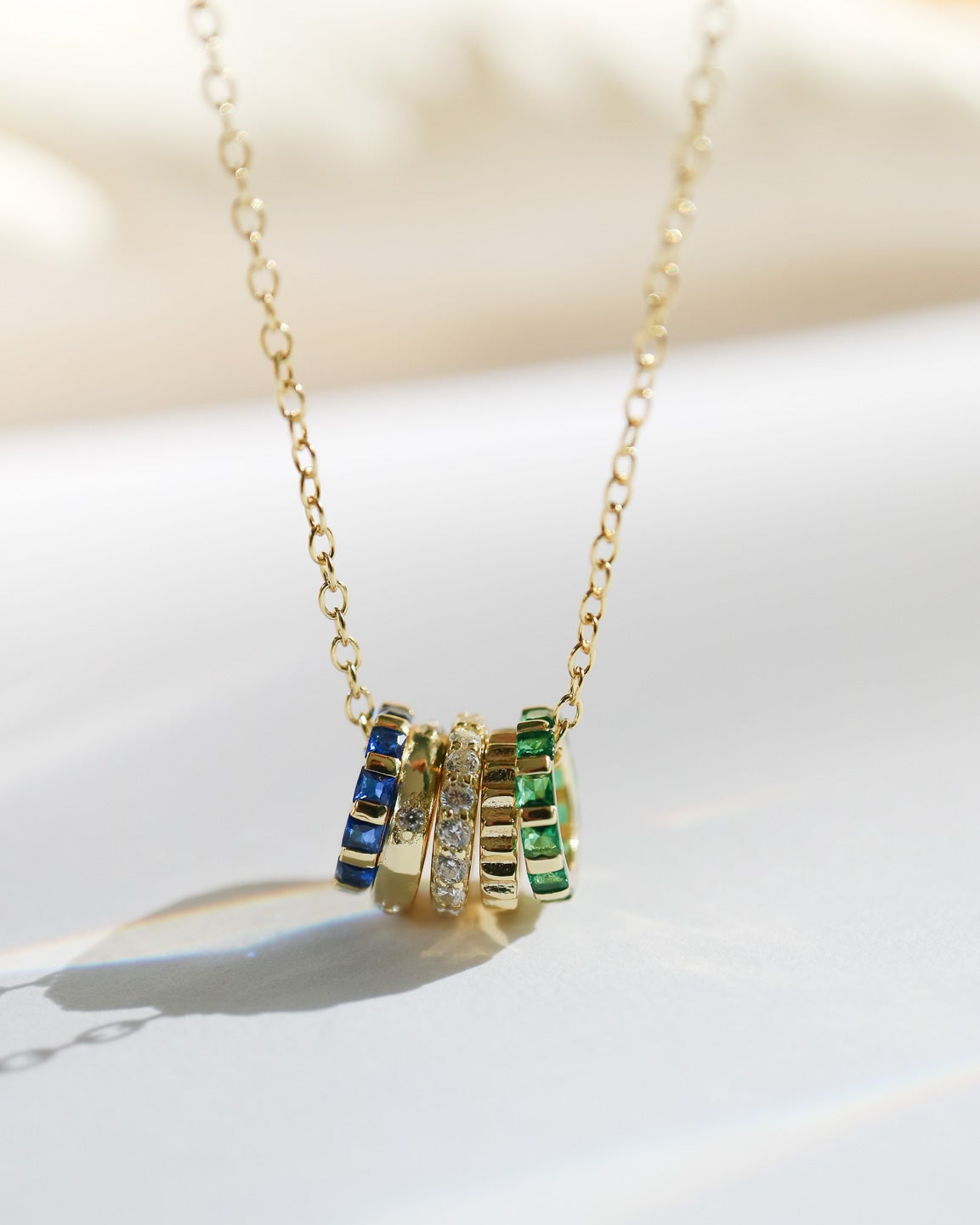14kt gold plated pendant with 5 rings and CZ gemstones