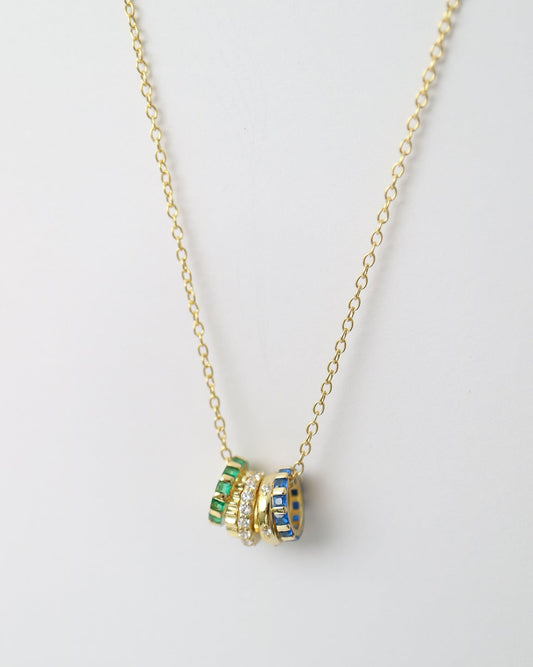 Necklace with green and blue gemstones on a light gray background