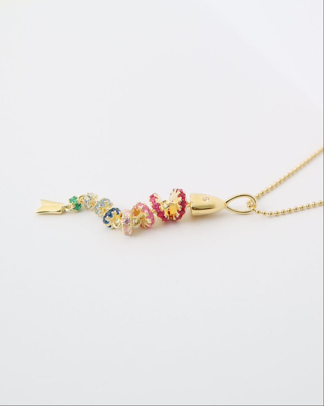Gold necklace with colorful beads on a white background