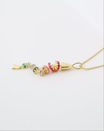 Gold necklace with colorful beads on a white background