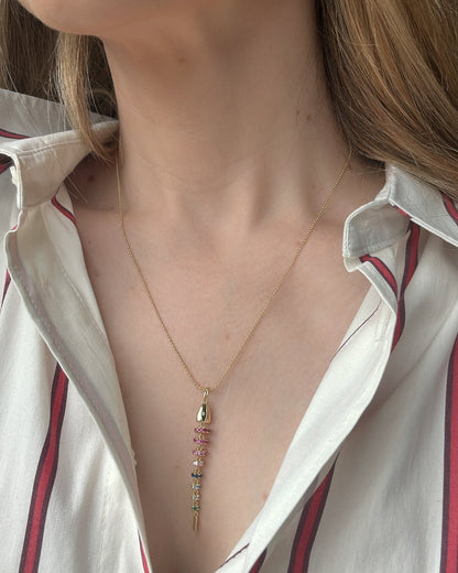 Close-up of a person wearing a delicate necklace with small pendants.