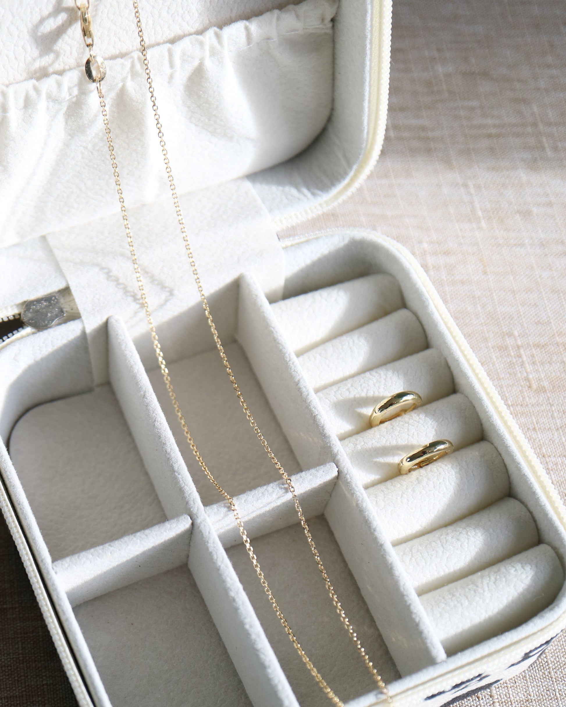 Jewelry box with necklaces and rings on a textured surface