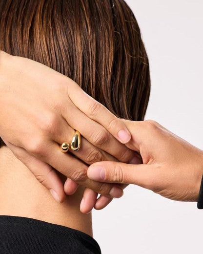 Person wearing gold jewelry with a plain background