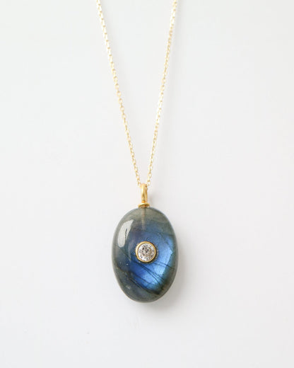 Eclipse Labradorite Pendant featuring a polished oval labradorite gemstone with natural blue flashes, a bezel-set cubic zirconia, and a gold plated sterling silver bail on a white background.