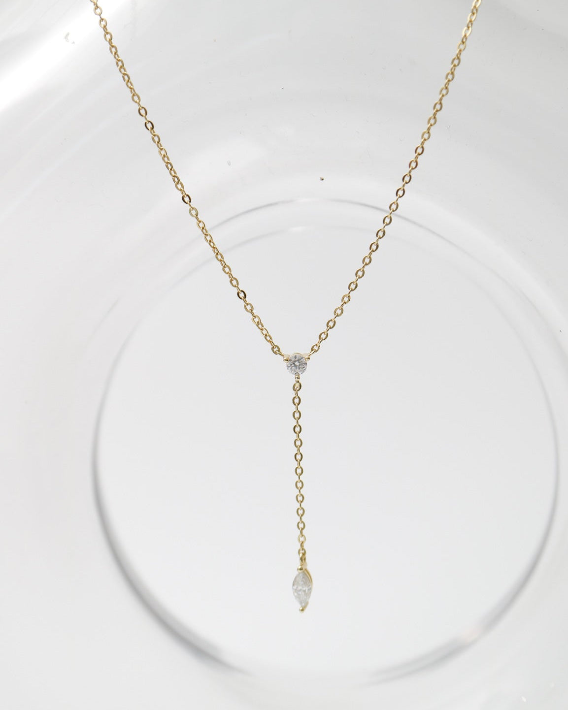 Gold necklace with a pendant on a white stand