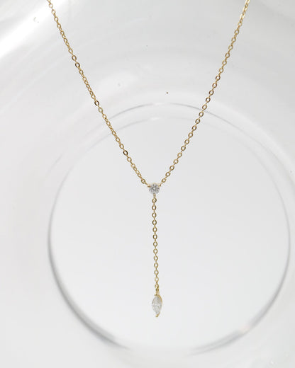 Gold necklace with a pendant on a white stand
