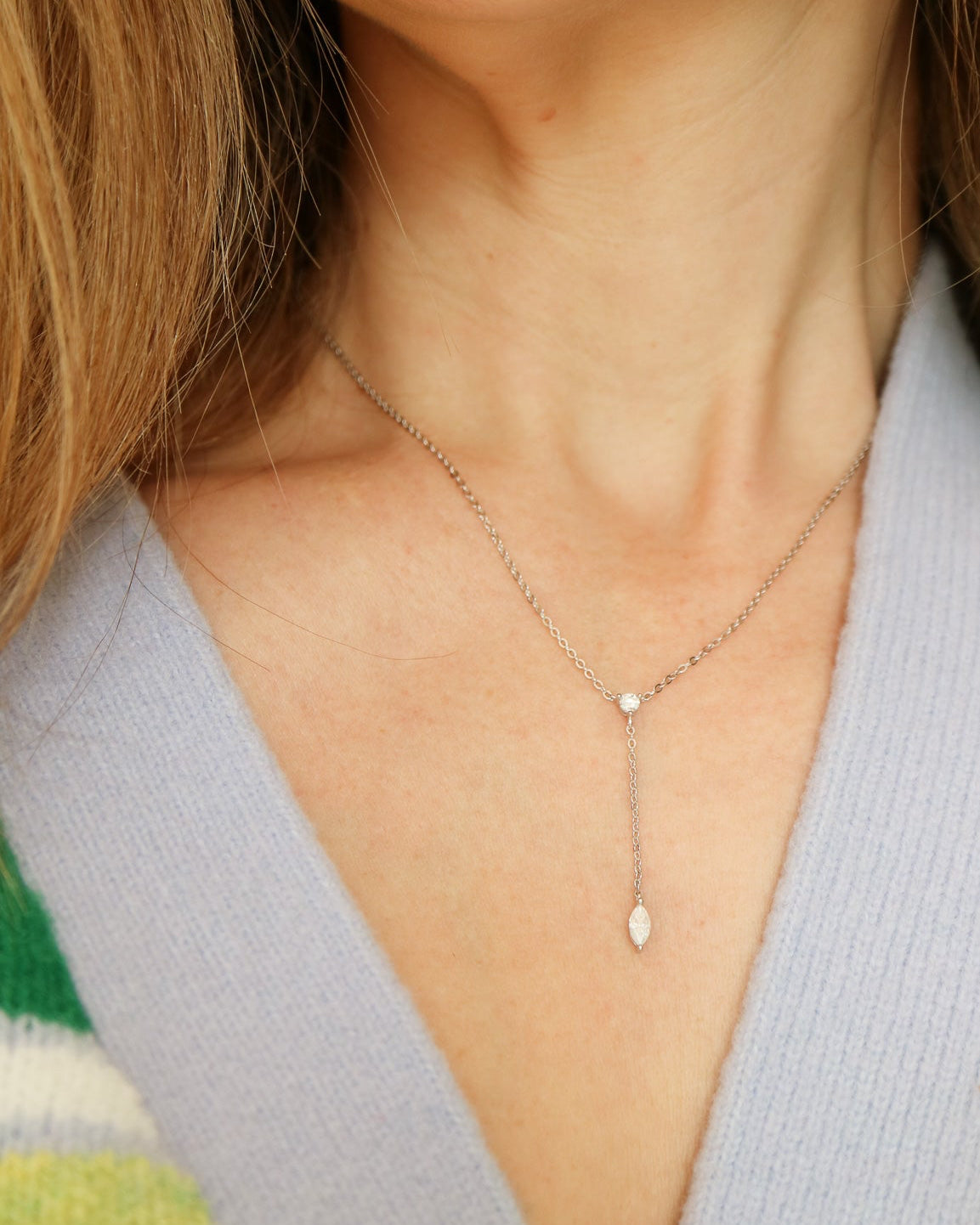 Necklace with small beads worn by a person against a neutral background