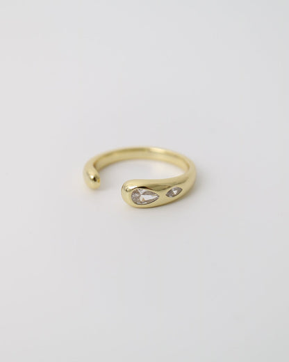 Close-up of a polished gold-plated statement ring with organic curves and two marquise-cut moissanite stones
