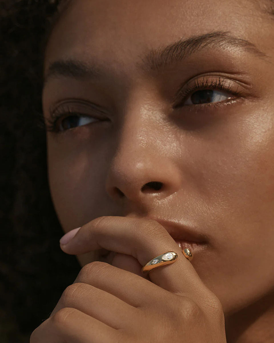Sculptural gold-plated ring featuring flush-set marquise moissanite stones, modern open band design