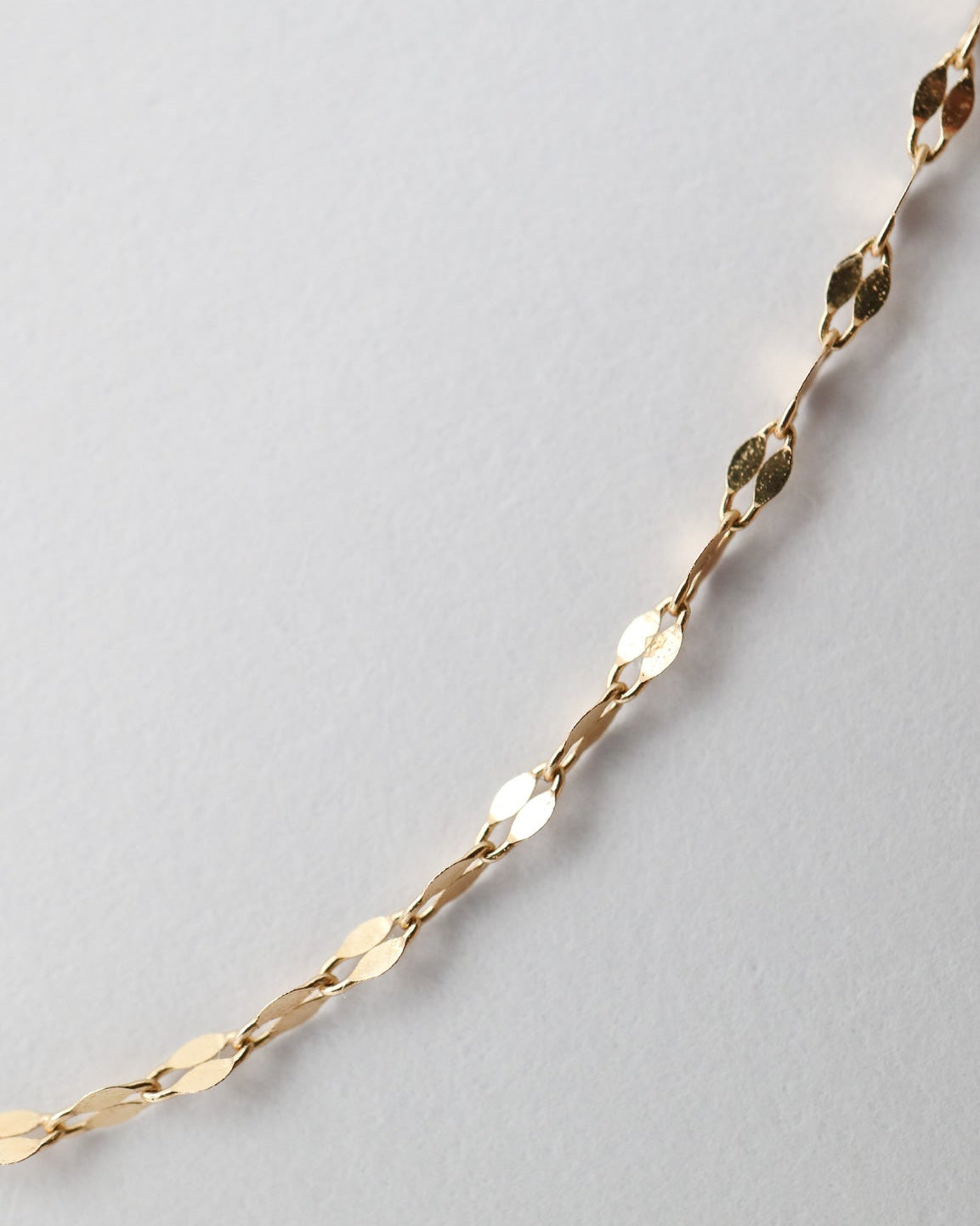 Fine 10ct yellow gold Whispers Chain with delicate faceted links and a polished finish displayed on a white background.