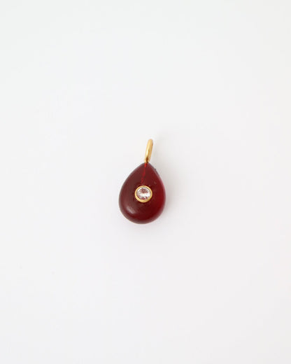 Garnet Glow Pendant featuring a deep red teardrop gemstone with a bezel-set cubic clear quartz and gold plated sterling silver bail on a white background.