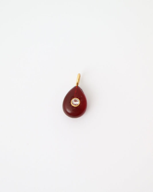 Garnet Glow Pendant featuring a deep red teardrop gemstone with a bezel-set cubic clear quartz and gold plated sterling silver bail on a white background.