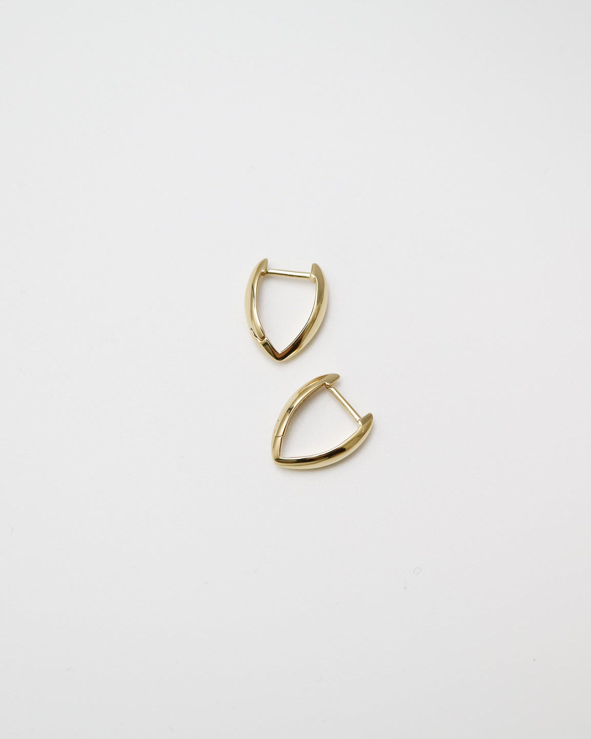 Pair of gold earrings on a light gray background