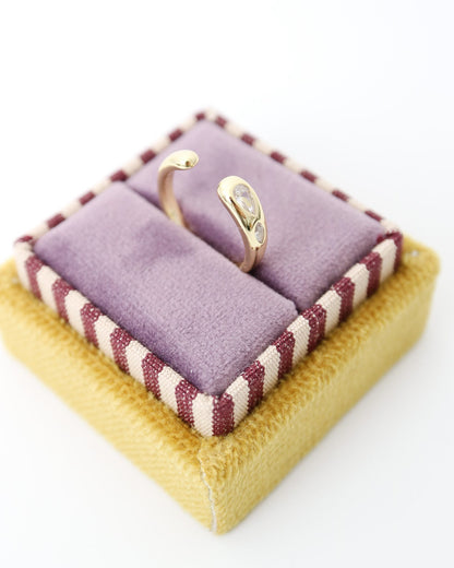 Gold-plated Elio Drop Ring with two flush-set marquise-cut moissanite stones on a sculptural curved band