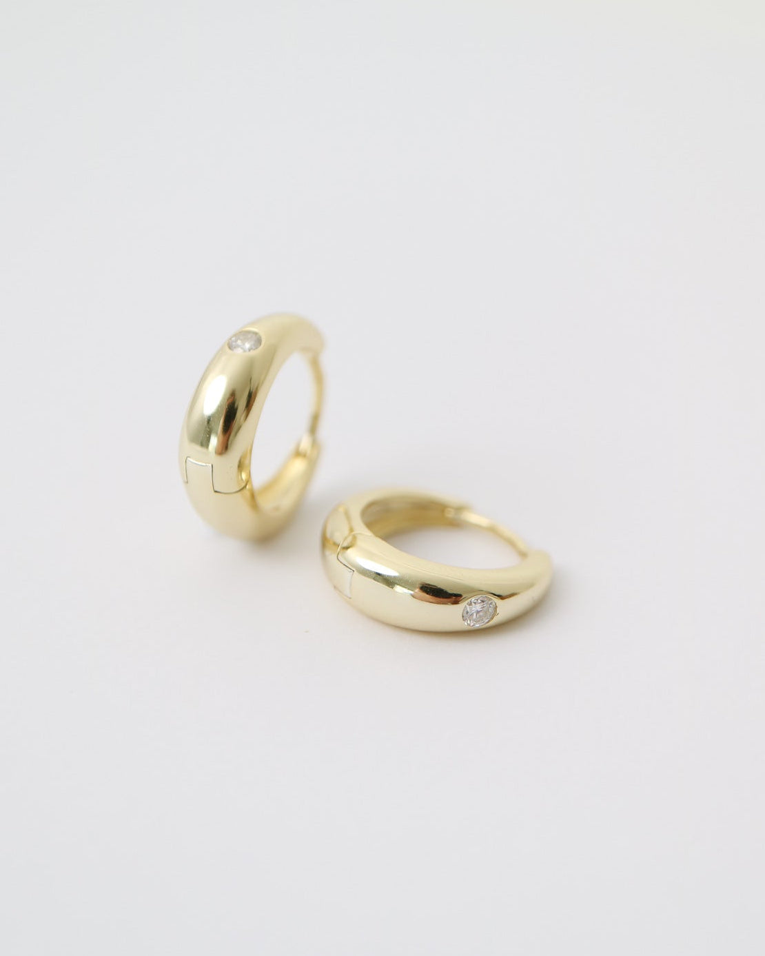 Two gold rings on a light gray background