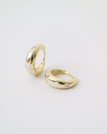 Two gold rings on a light gray background