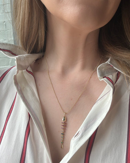 Close-up of a person wearing a necklace with a white shirt and red stripes.