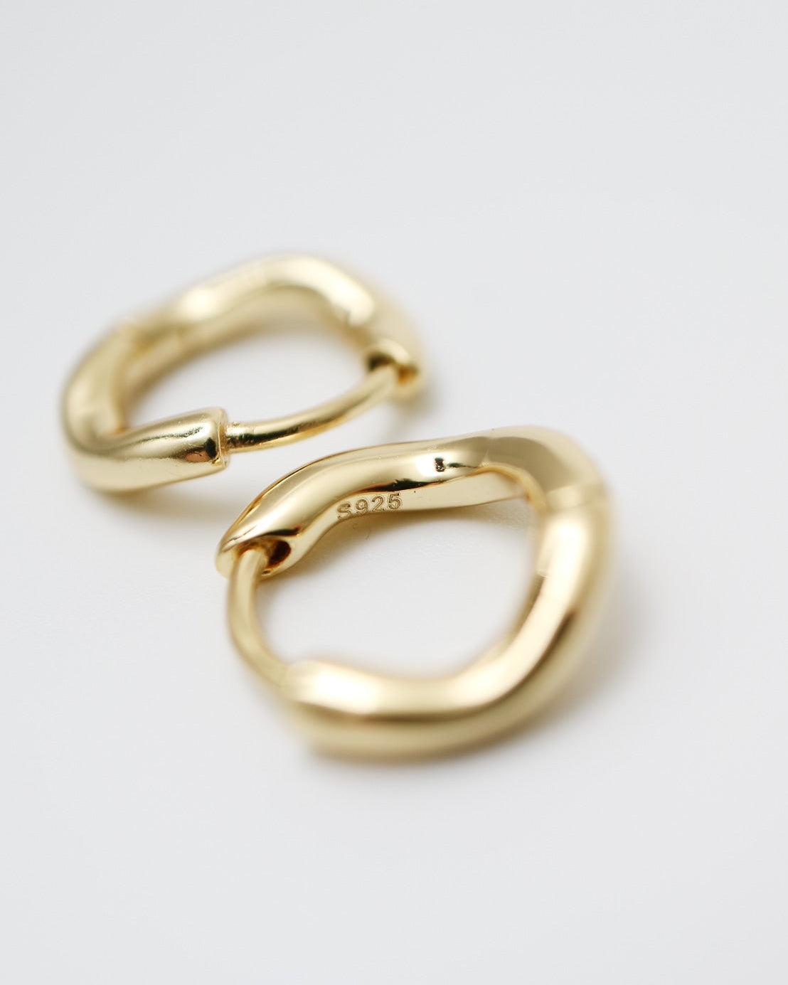 Gold hoop earrings on a light gray background