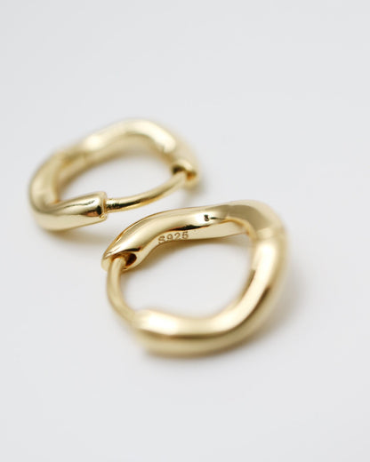 Gold hoop earrings on a light gray background