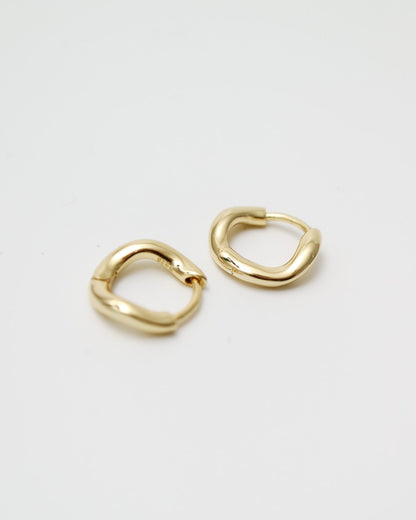 Pair of gold hoop earrings on a light gray background