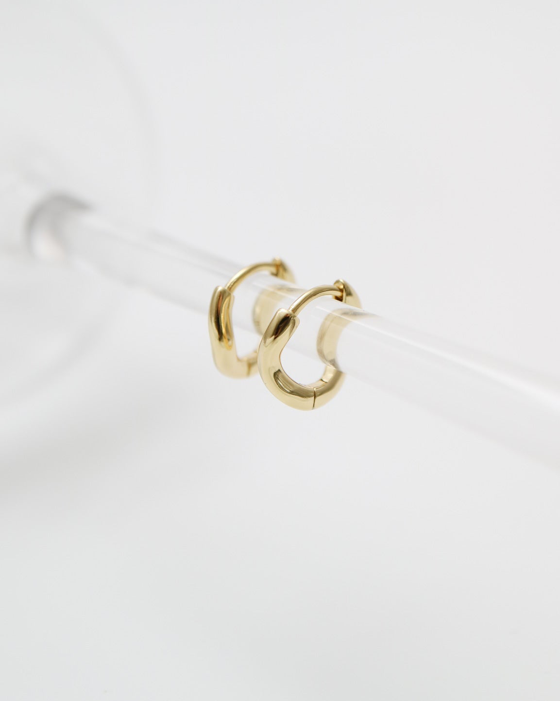Gold hoop earring on a white background