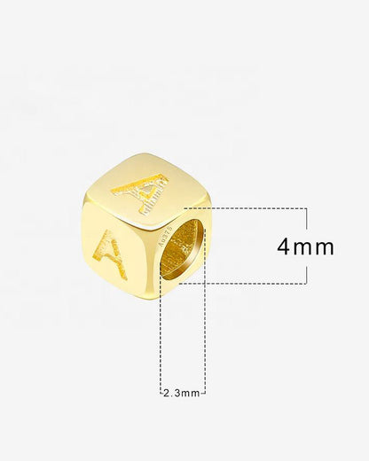 Gold bead with letter 'A' engraving and measurements on a white background