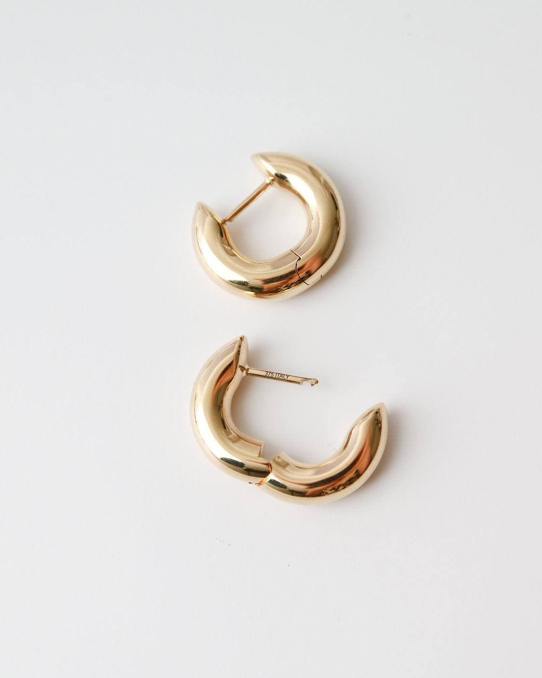Pair of gold hoop earrings on a light gray background