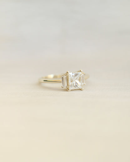 Gold ring with a diamond on a beige background