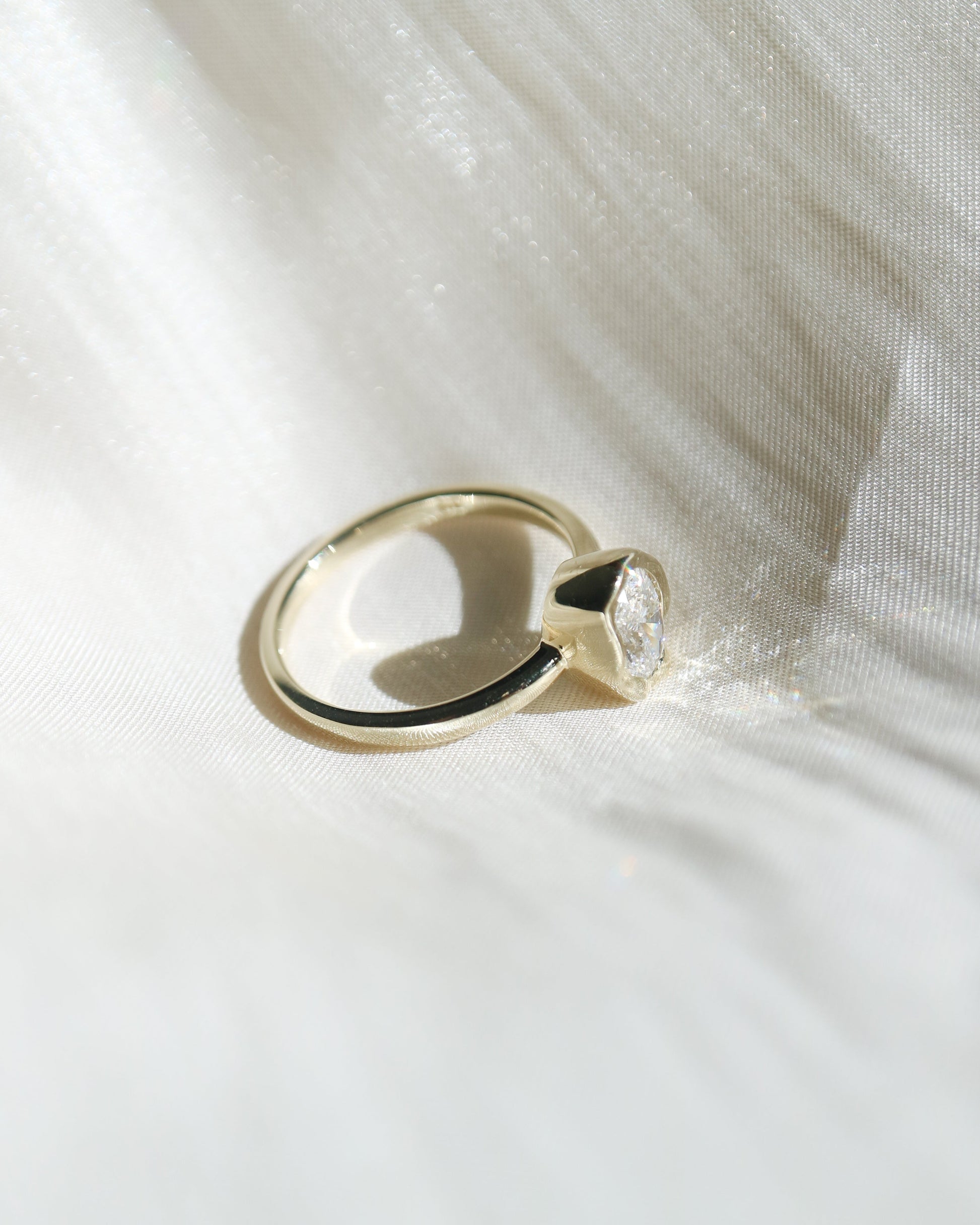 Gold ring with a unique design on a white fabric background