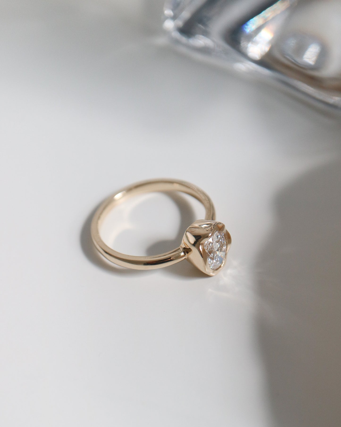 Gold ring with a diamond on a white surface
