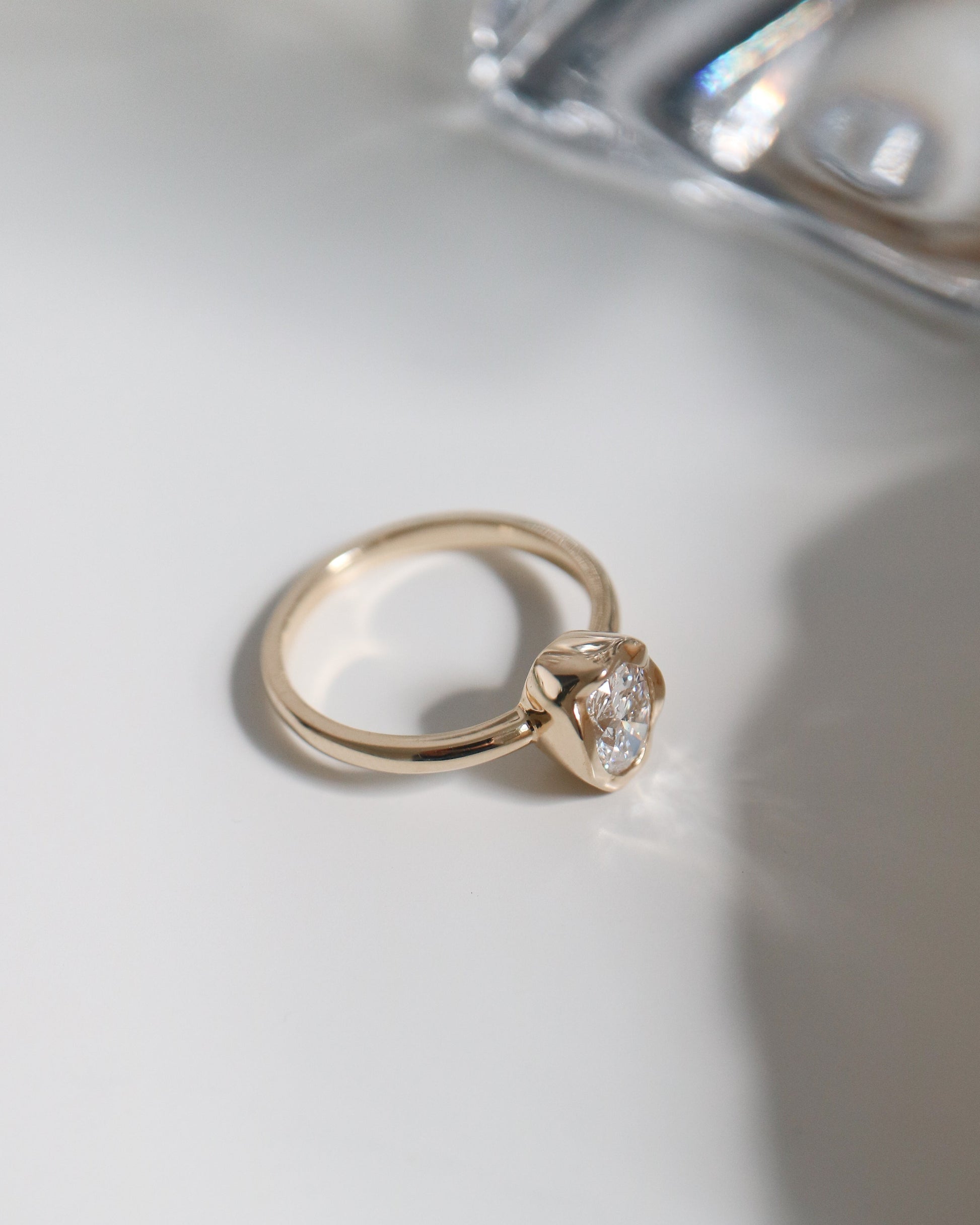 Gold ring with a diamond on a white surface