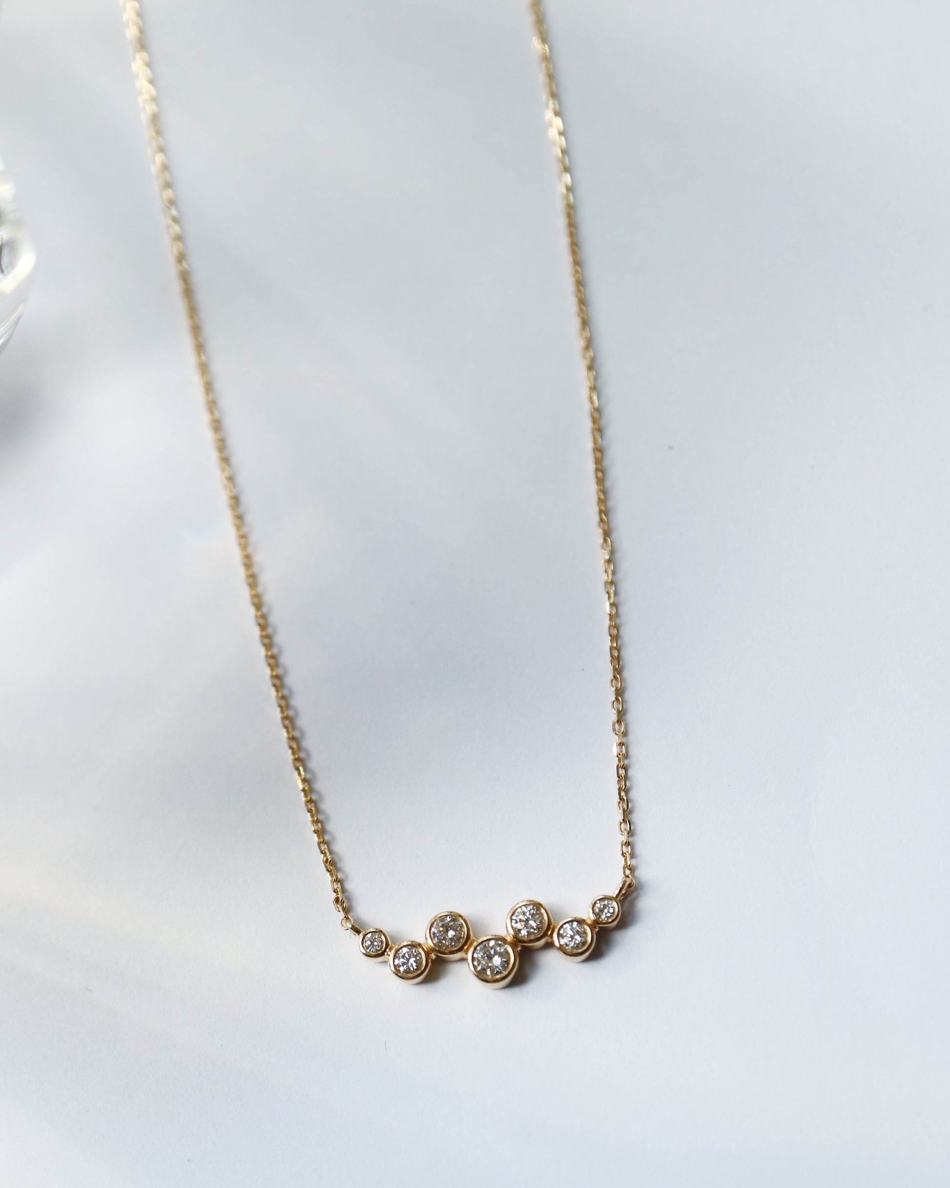 Gold necklace with small diamonds on a white background