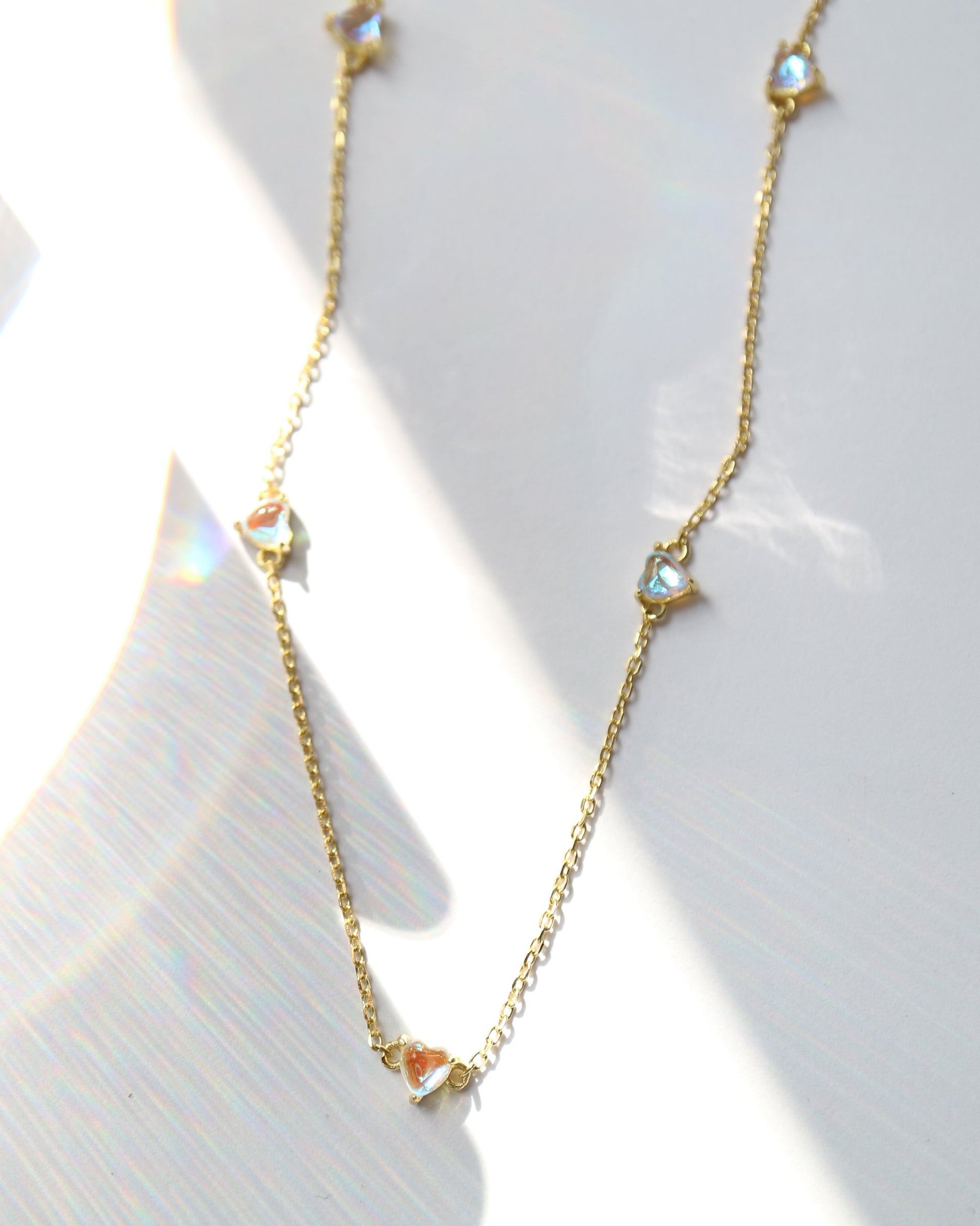 Gold necklace with small diamonds on a white background