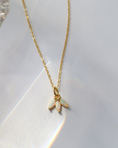 Gold necklace with an opal pendant on a white background