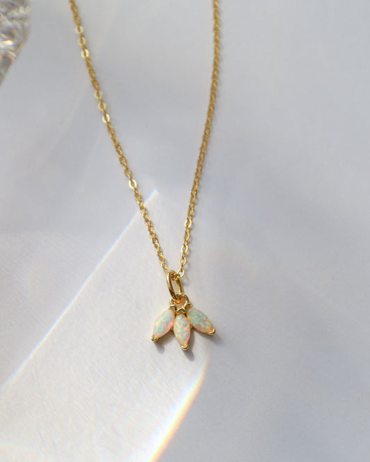 Gold necklace with an opal pendant on a white background