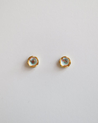Pair of gold stud earrings on a light gray background
