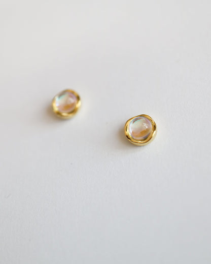 Pair of gold earrings with moonstone gemstones on a light gray background