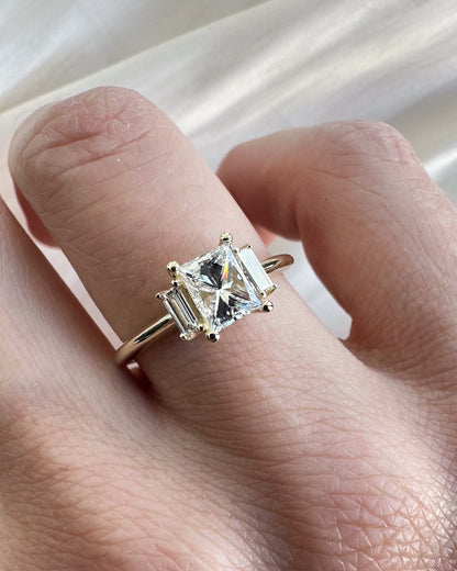 Gold ring with a diamond on a hand against a white background