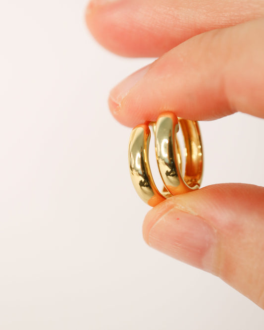 Gold ring on a finger against a white background