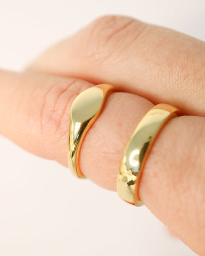 Gold ring on a finger against a white background