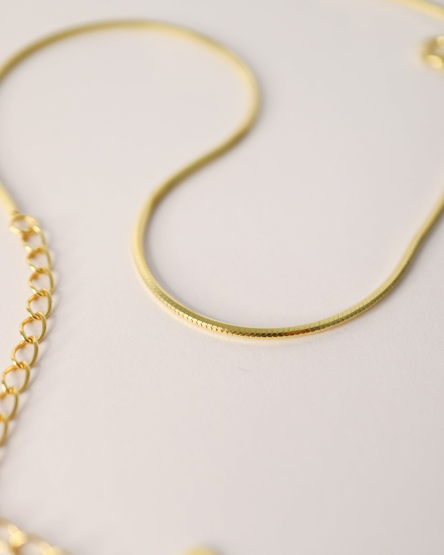 Gold bracelet on a light gray background