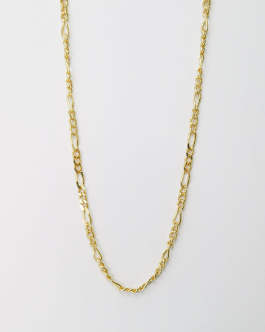Gold chain necklace on a light gray background